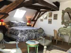 TaingyManoir de La Croix Saint Louis "Luxury Guest House"的卧室配有一张床和一张桌子及椅子