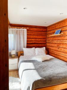 图哈Jūras Pērle的一间卧室设有一张带木墙的大床