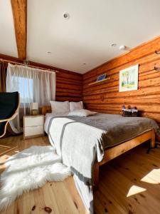 图哈Jūras Pērle的卧室配有一张木墙内的大床