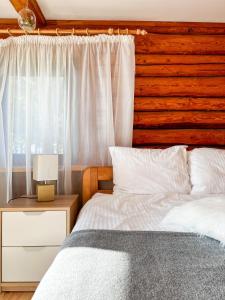 图哈Jūras Pērle的一间卧室设有一张床和木墙