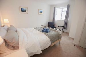 Perranuthnoe3-Bedroom bungalow with parking, Goldsithney, Penzance, Cornwall的卧室设有一张白色大床和一扇窗户。