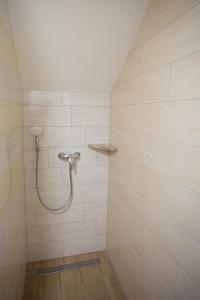 布莱德APARTMAJI HUBI的白色瓷砖浴室内带软管的淋浴