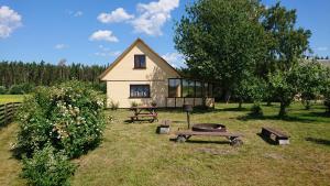 尤卡尔内Pirmie Zaļmeži的院子里带烧烤架和野餐桌的房子