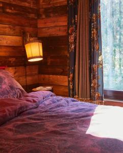 胡法利兹Tiny House Cetturu - 2-pers luxe en romantisch boshuisje的一间卧室配有一张带灯和窗户的床