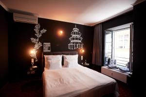 慕尼黑WDREI Hotel的一间卧室配有一张大床和一个吊灯。