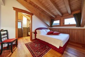 San Nicolò di Comelico博托多罗农家乐的一间卧室配有一张带红色枕头的床