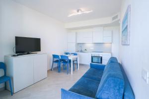 圣托·斯特凡诺·阿尔马尔H11 LUXURY 3B - Porto - Piscina - Jacuzzi的一间带蓝色沙发的客厅和一间厨房