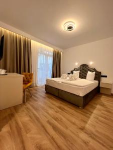 索瓦塔Vila Noblesse的一间卧室设有一张大床,铺有木地板