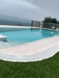 下布雷尼亚Casa Nine con piscina的一座蓝色的海水和草地大型游泳池