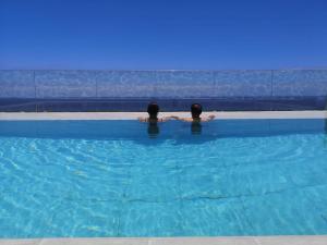 下布雷尼亚Casa Nine con piscina的两个人坐在游泳池里