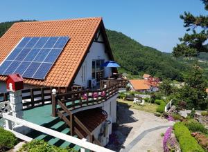 南海郡Namhae German Village Johannes的屋顶上设有太阳能电池板的房子