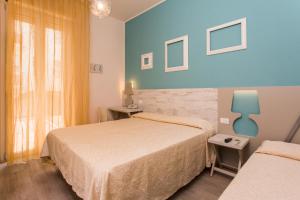 切塞纳蒂科Hotel Trieste的酒店客房设有两张床和窗户。