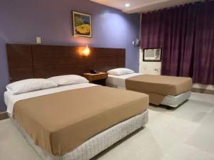 马尼拉BEST FORTUNE HOTEL at CHINATOWN的酒店客房设有两张床和紫色的墙壁。