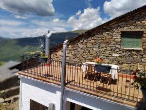 Los MolinosCasa rural con vistas en el corazón del Pirineo的大楼内的阳台配有桌椅