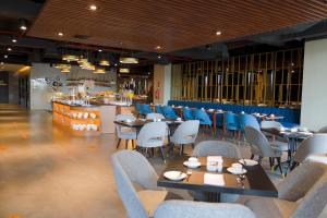 泗水Grand Swiss-Belhotel Darmo的一间带桌椅的餐厅和一间酒吧