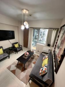 马尼拉Resorts World Condo的客厅配有沙发和桌子