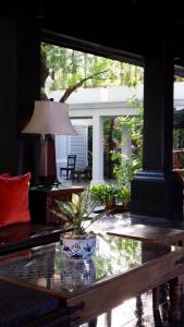 清迈马卡酒店的客厅配有玻璃桌和灯