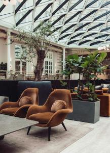 哥本哈根Villa Copenhagen的大堂设有两把椅子和一张桌子,种植了植物
