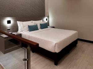 那牙The Litton Hotel by Carterson的一间卧室配有一张带蓝色枕头的大床