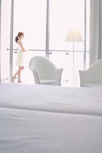 蓬他达维托亚艾特塔拉根达彭塔度索尔酒店的穿着白色衣服的女人在卧室里走
