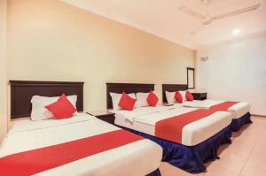 安顺Hotel Home 88的两张位于酒店客房的床,配有红色和白色枕头
