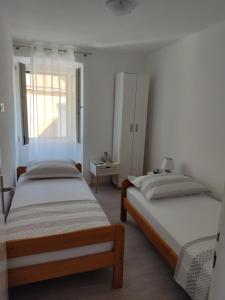 圣内德尔贾Apartment Zagalo的一间卧室设有两张床和窗户。