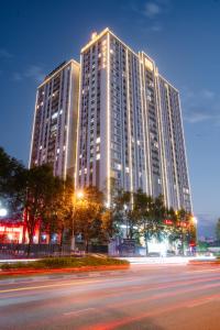 北宁Grand Phoenix Hotel Bac Ninh的一座高大的建筑,上面有灯