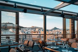 雅典伊利索斯酒店的一间带桌椅的市景餐厅