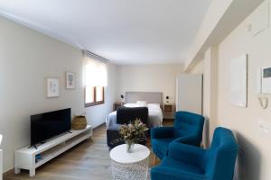 莱昂Housingleón Azabachería 22的客厅配有床和2把蓝色椅子