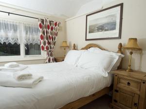 惠特比The Endeavour的卧室配有白色的床和2条毛巾