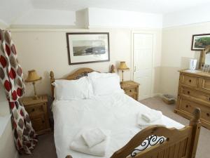 惠特比The Endeavour的一间卧室配有一张带2个床头柜的大型白色床