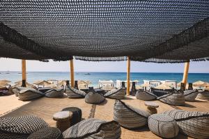 PaliochoriArtemis Seaside Resort的海滩上的一组椅子和遮阳伞