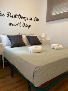 圣玛丽亚港Life Apartments Fuentebravía的卧室里有一张床,上面写着生活中最好的东西都是不正确的