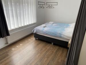 沃尔堡HaagsHuisje- eigen appartement, dichtbij alles, stijlvol的一间卧室配有一张床,铺有木地板