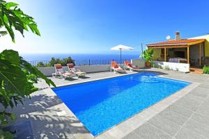 蒂哈拉费Villa Ivan的一个带椅子的游泳池,背景是大海
