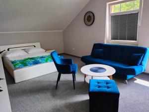 SpytkowiceNoclegi Zator Energylandia的一间卧室配有一张床、蓝色的椅子和一张桌子