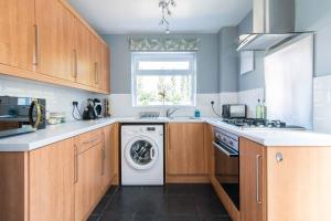 达宁顿堡Modern three bedroom home in Castle Donington的厨房配有洗衣机和窗户。