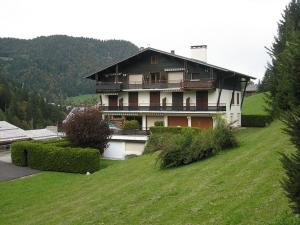 拉克吕萨Appartement La Clusaz, 3 pièces, 8 personnes - FR-1-459-5的一座大房子,位于绿色的山顶上