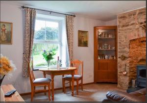 林顿The Annex Rose Cottage的一间带桌子和窗户的用餐室