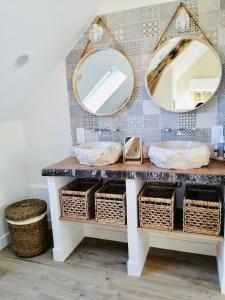 ChoussyChambres d'hôtes L'Escale Charmante的浴室设有梳妆台、两面镜子和篮子