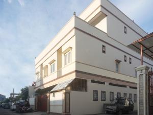 马卡萨OYO 91316 Hh Guest House Makassar的前面有一辆汽车停放的白色建筑
