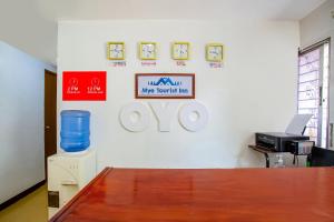 马尼拉OYO 808 Mye Tourist Inn的墙上有桌子和标志的办公室