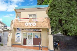 马尼拉OYO 808 Mye Tourist Inn的前面有卵石标志的建筑