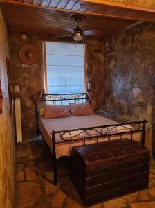 皮洛斯Maggie's Traditional home的一间卧室设有一张床和石墙