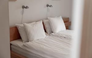 博里霍尔姆Ekerum Village的一张带白色床单和枕头的床