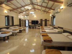 达博利Cocorico Beach Resort的客房设有一排床铺和电视。