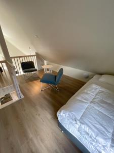 韦斯特罗斯Rocklunda Village的一间卧室配有一张床、一把椅子和楼梯