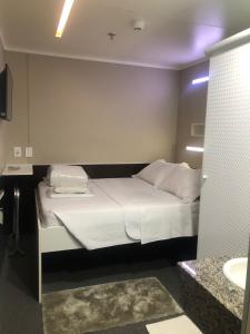 坎皮纳斯Hotel Aero Sleep Campinas的卧室配有白色的床和水槽