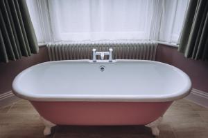 吉尔福德德拉蒙德奥尔伯里宾馆的带浴缸的浴室和窗户