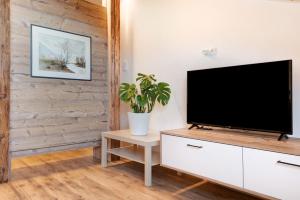 马兰扎Apartment Schöne Aussicht的客厅设有木墙,配有平面电视。